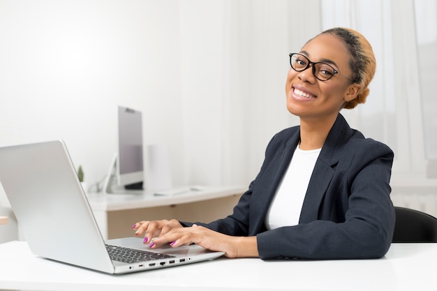 Portrait of a smiling business African American woman working on computer.