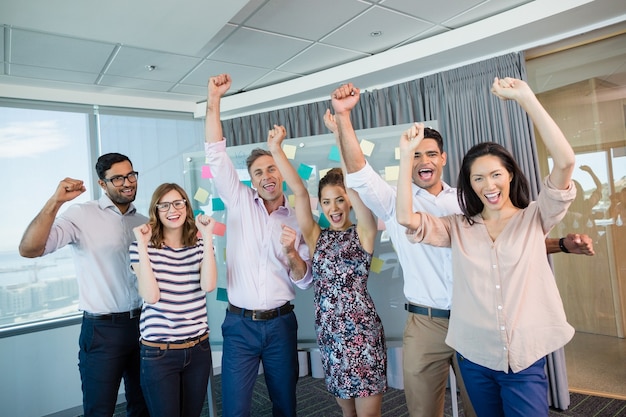 Portrait of smiling business colleagues cheering with fists up