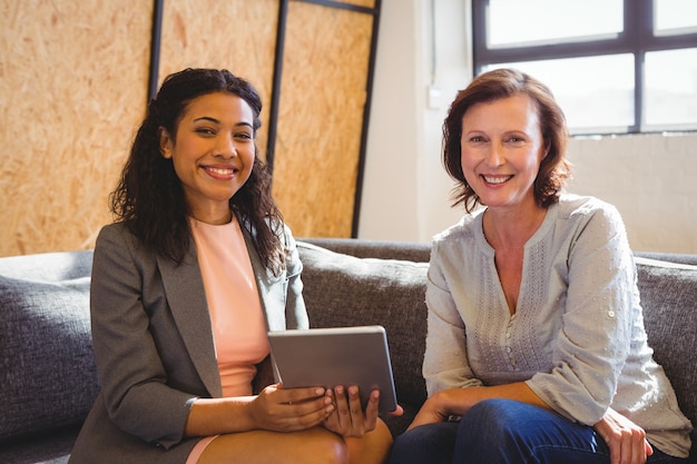 Portrait of smiling business executives holding digital tablet