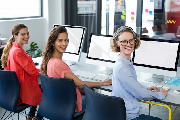 Ritratto degli uomini d'affari sorridenti che lavorano al computer