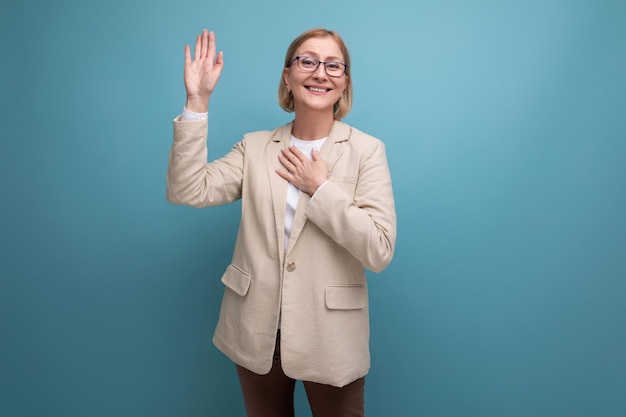 Portrait of a smiling business s mature woman in a classic jacket on a bright background with copy