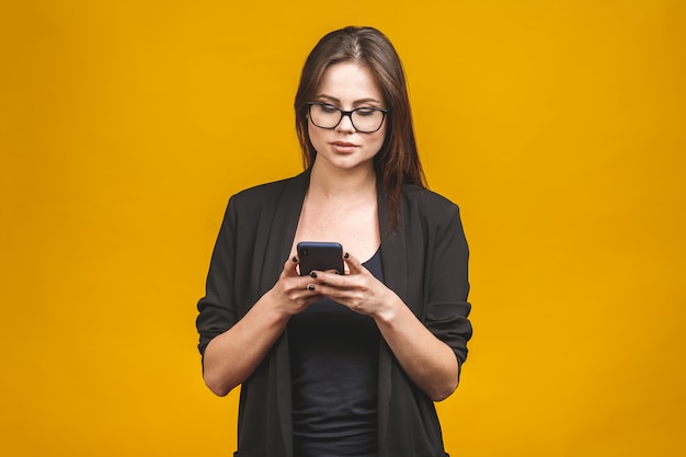 Ritratto della donna sorridente di affari in occhiali che tengono smartphone