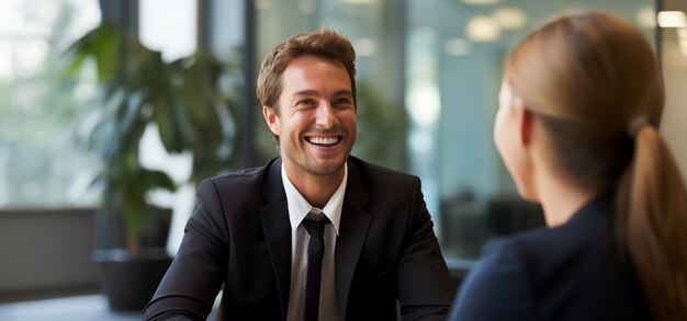 Portrait of smiling businessman and businesswoman talking in office Focus on man