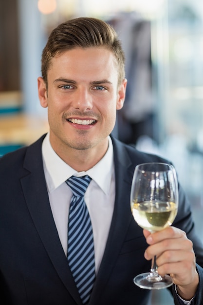 Ritratto dell'uomo d'affari sorridente che tiene un vetro di birra