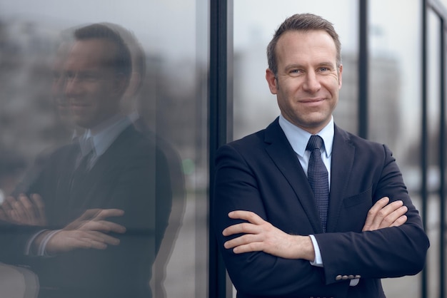 Photo portrait of smiling businessman standing outside office