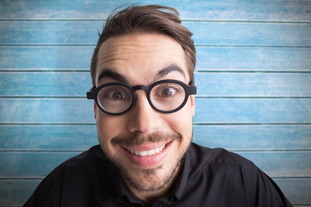 Photo portrait of a smiling businessman with glasses against wooden planks