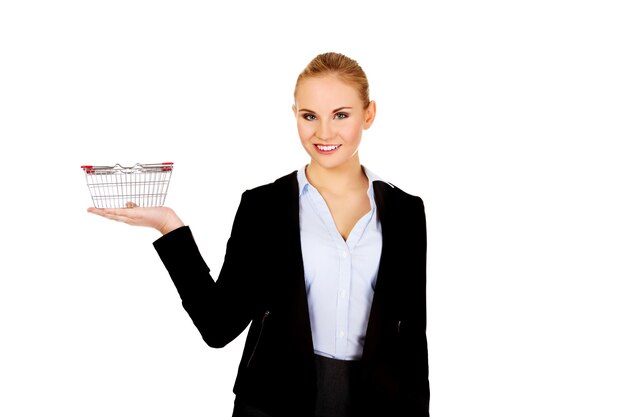 Portrait of smiling businesswoman holding basket while standing against white background