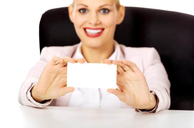 Photo portrait of smiling businesswoman holding blank card against white background