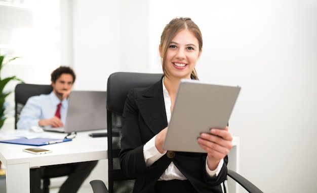 Portrait of a smiling businesswoman using a tablet in her office