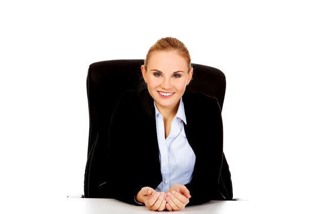 Portrait of smiling businesswoman with hands cupped sitting against white background