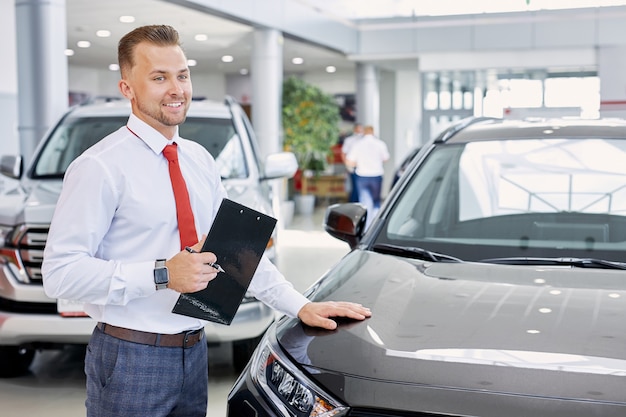 Portrait of smiling car dealer at work