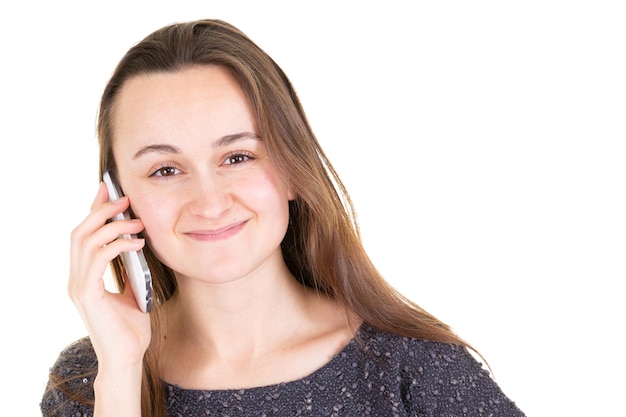 Portrait of smiling casual beautiful young woman holding smartphone over white background