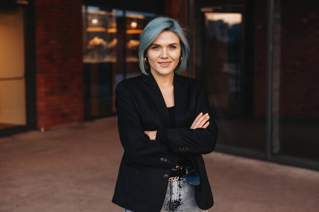 Portrait of a smiling caucasian businesswoman standing with crossed arms and looking at camera busin...