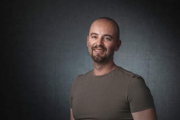 Portrait of smiling caucasian man with t-shirt on dark