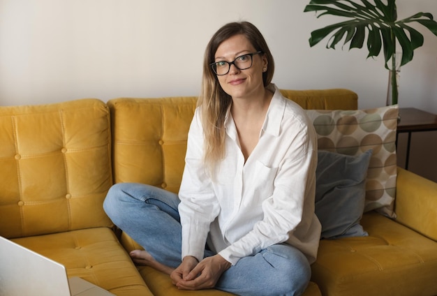 Portrait of smiling caucasian middleaged brunette business woman freelancer using phone sitting with