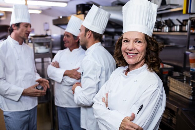 Портрет улыбающегося шеф-повара в коммерческих кухне