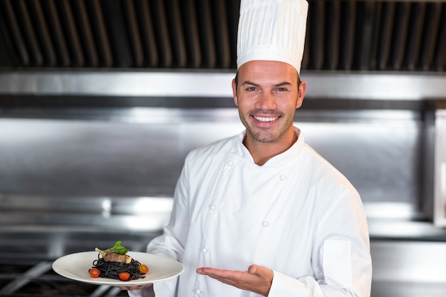 Portrait of smiling chef holding plate