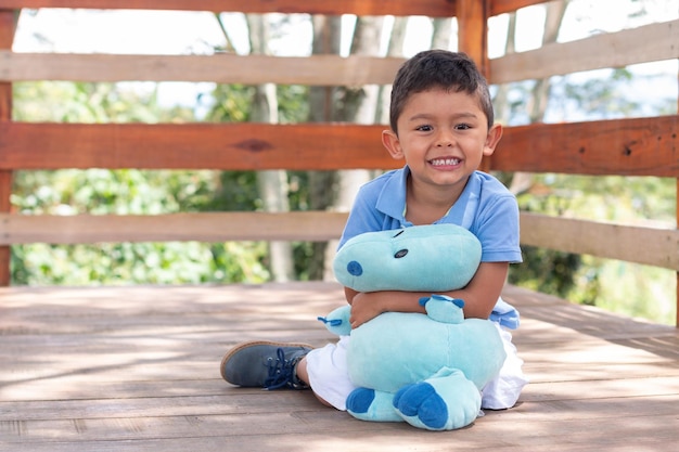 Portrait of a smiling child Cute happy child hugging his blue stuffed animal