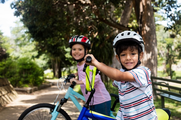 公園で自転車で立っている笑顔の子供たちの肖像画