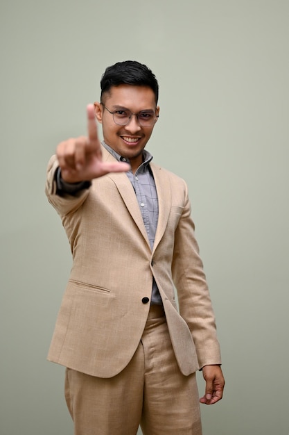 Portrait of a smiling and confident millennial Asian businessman showing correct gesture