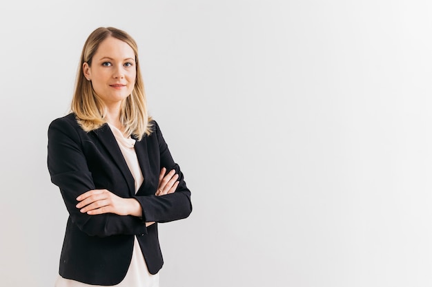 Photo portrait of smiling confident young businesswoman with arm crossed