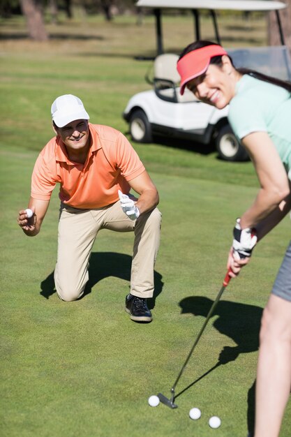 Portrait of smiling couple playing golf