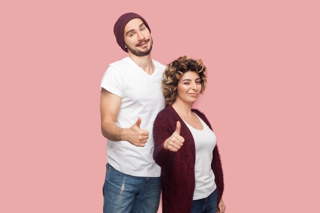 Photo portrait of smiling couple standing against pink background