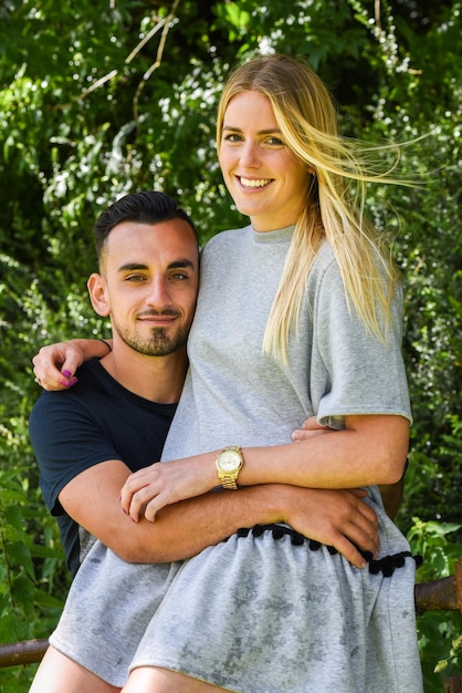 Photo portrait of smiling couple standing against plants at yard