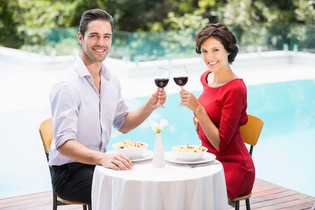 Portrait of smiling couple toasting red wine