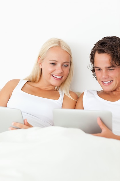 Photo portrait of a smiling couple using tablet computers