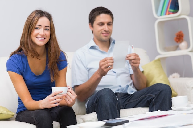 Portrait of a smiling couple with bills at home