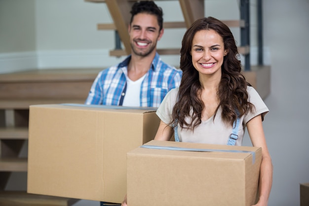 Portrait of smiling couple with cardboard boxes