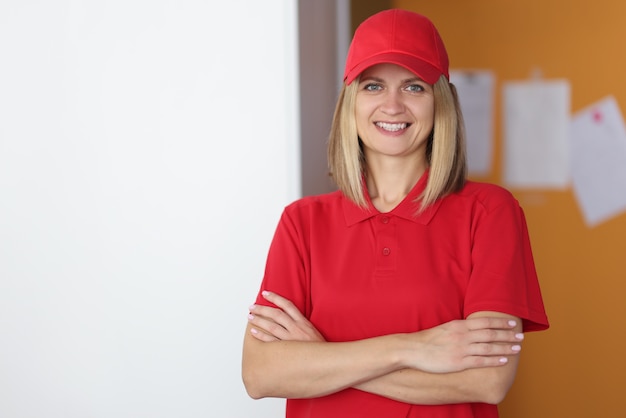 Portrait of smiling courier woman in red uniform