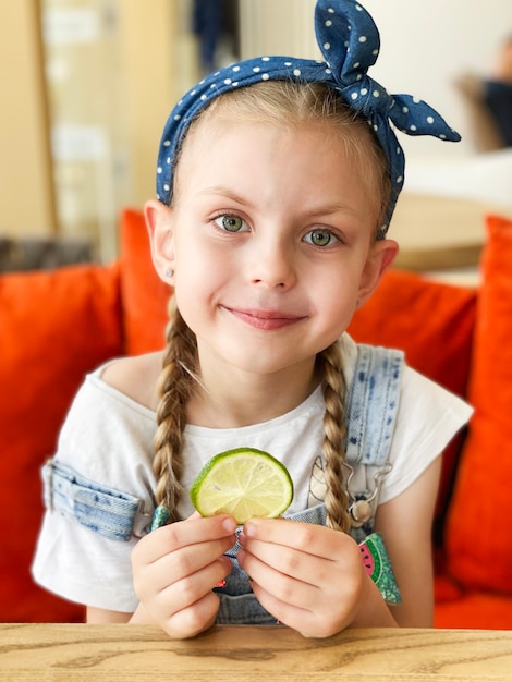 Portrait of smiling cute little girl holding lime slices