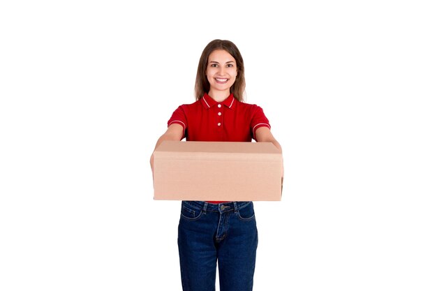 Portrait of smiling delivery woman holding package while standing against white background