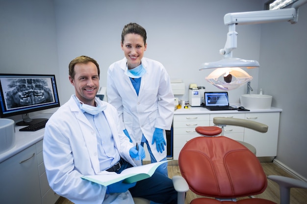 Portrait of smiling dentists holding medical report