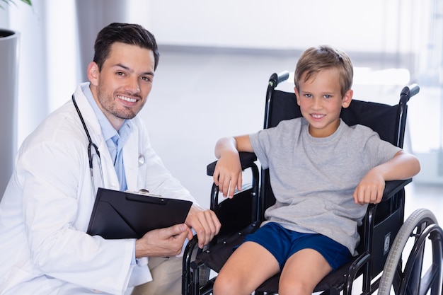 Il ritratto di medico sorridente e disattiva il ragazzo in corridoio