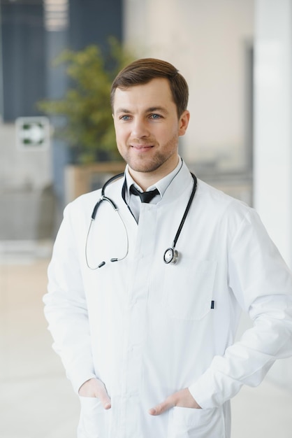 Portrait of smiling doctor in uniform standing in medicine clinic hall