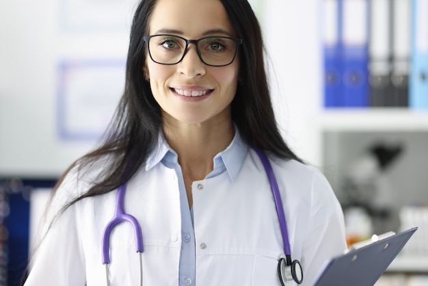 Portrait of smiling doctor with glasses in medical office. Medical care and services concept