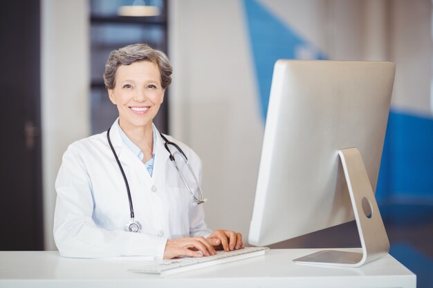 Portrait of smiling doctor working at computer desk