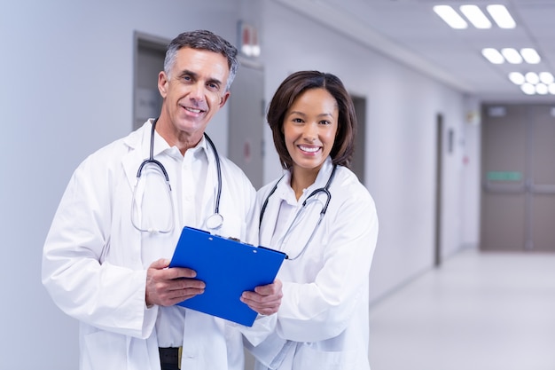 Portrait of smiling doctors standing in corridor