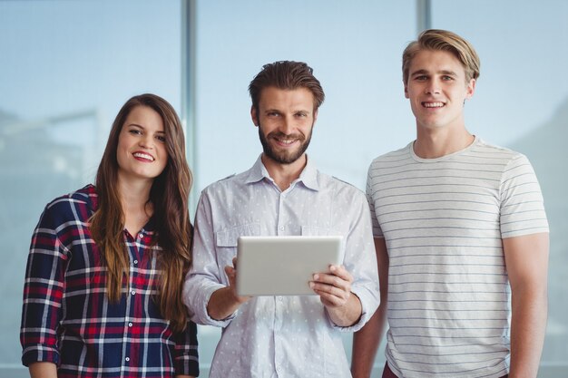 Portrait of smiling executives using digital tablet