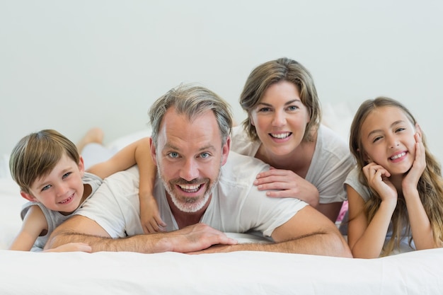 Ritratto di famiglia sorridente sdraiato sul letto in camera da letto