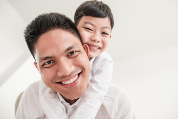 portrait of smiling father piggybacking son
