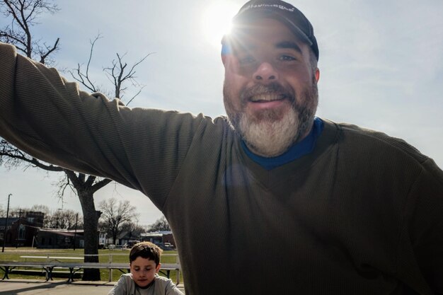 Photo portrait of smiling father with son sitting in background