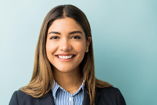 Portrait of smiling female business executive with long hair against isolated background