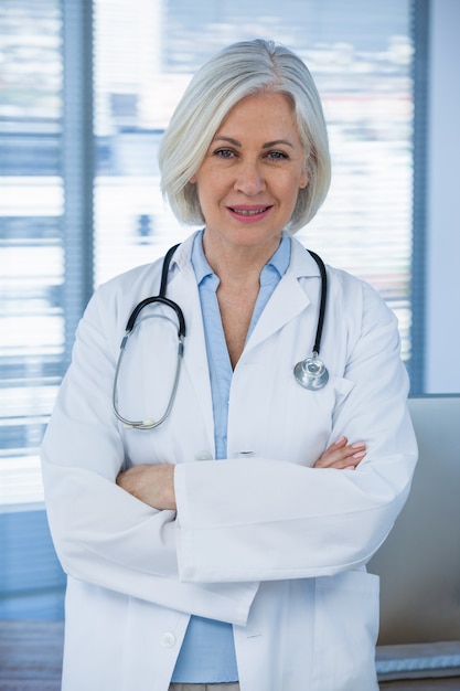 portrait of a smiling female doctor standing with arms crossed
