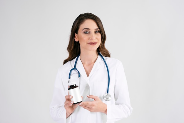 Photo portrait of smiling female doctor with stethoscope and medicament