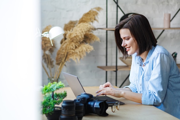 Portrait of smiling female freelancer using laptop.