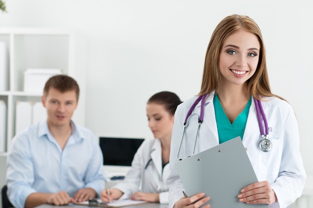 Portrait of smiling female medicine doctor with her colleague consulting male patient. Healthcare and medicine concept.